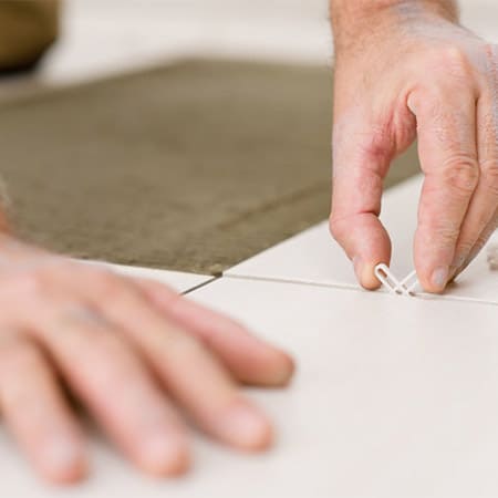 Home improvement - handyman placing tile spacer by CandyBoxImages.