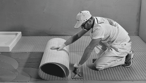 Roll Nuheat Membrane onto the thinset mortar and press with a roller or a flat trowel. Lay down the next sheet and align it with the previous one without overlapping. Line up the pillars to facilitate the installation of the heating cable.