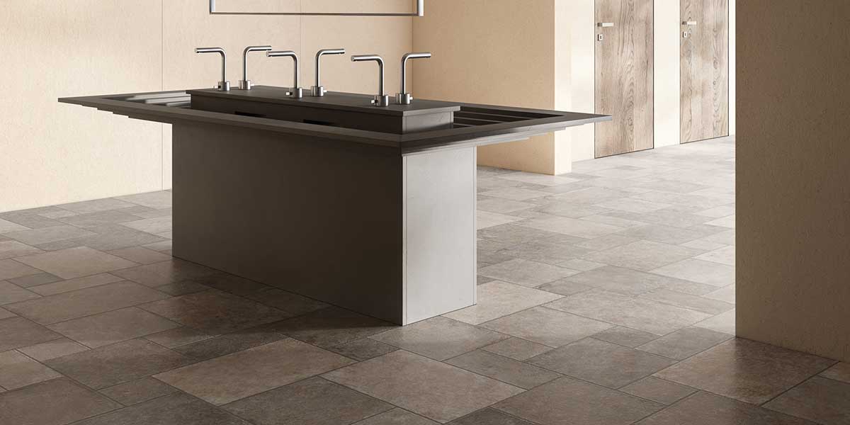 Modern commercial restroom featuring Pietra di Trani Tufo stone-look porcelain tile flooring.