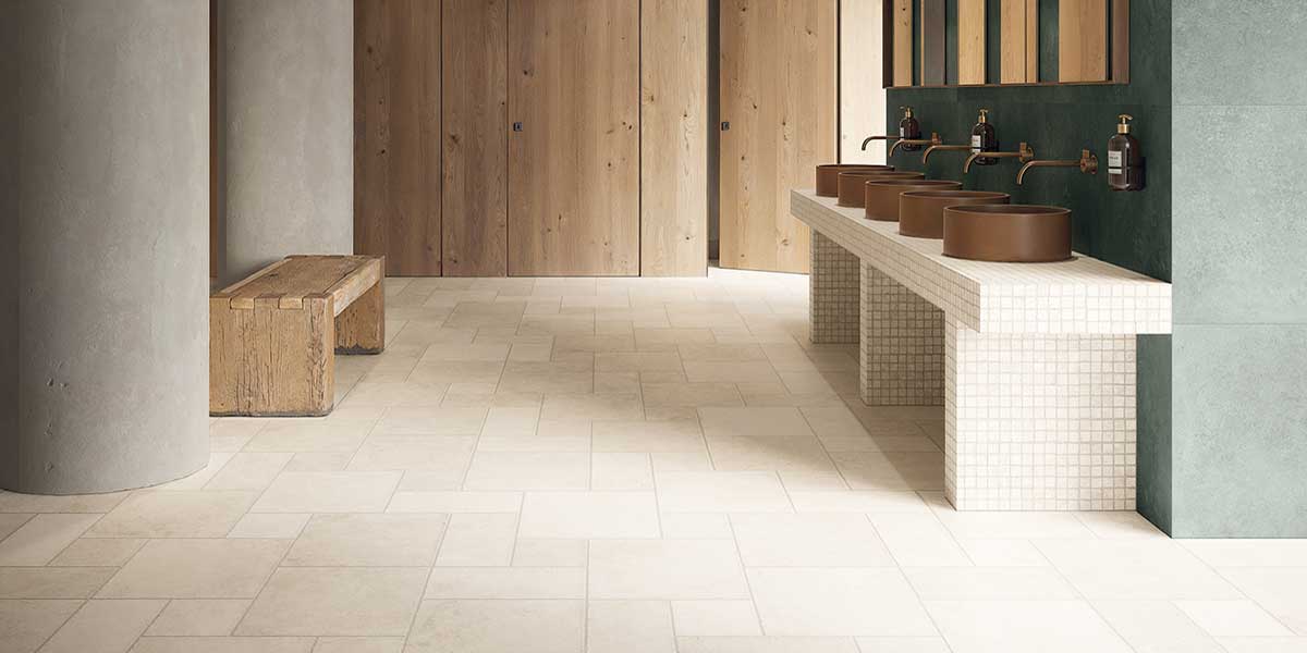 Contemporary commercial bathroom featuring Pietra di Trani Biancone stone-look porcelain tile flooring.