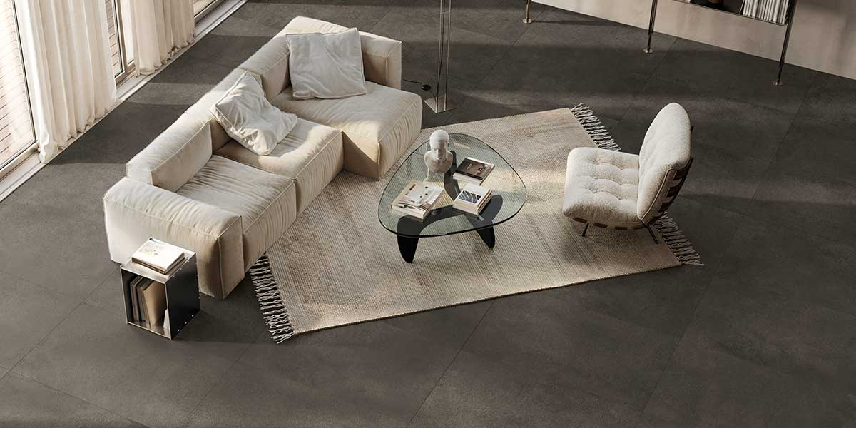 Modern living room featuring Pure Concrete Black concrete-look porcelain tile flooring.