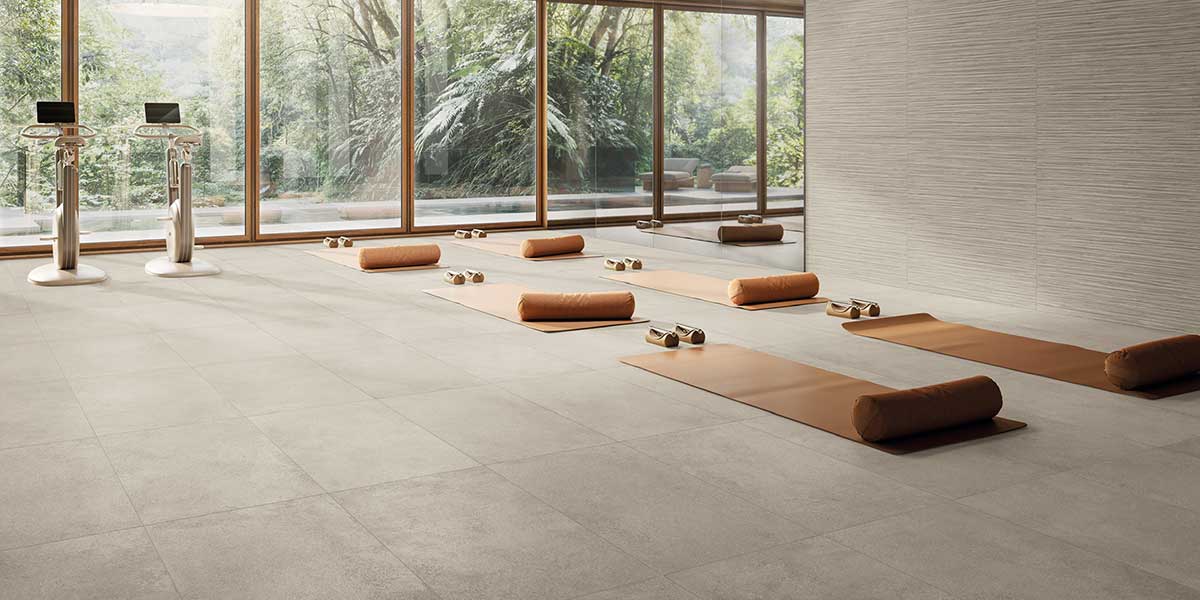 Wellness studio featuring Pure Concrete Greige concrete-look porcelain tile flooring and textured wall tile.