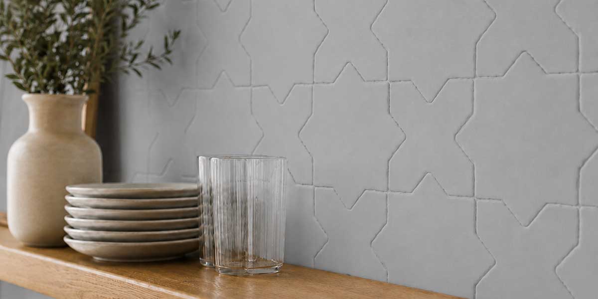 Close-up of Star & Cross Blue Grey matte porcelain tile installed on a kitchen wall.