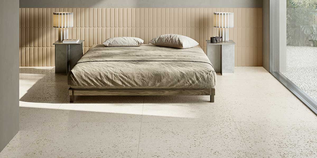 Bits Ivory terrazzo-look porcelain floor tile in a warm contemporary bedroom with decorative wall tile.